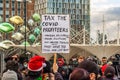STRATFORD, LONDON, ENGLAND- 5 December 2020: Anti-lockdown Standupx protester holding a Ã¢â¬ËTax the covid profiteersÃ¢â¬â¢ placard